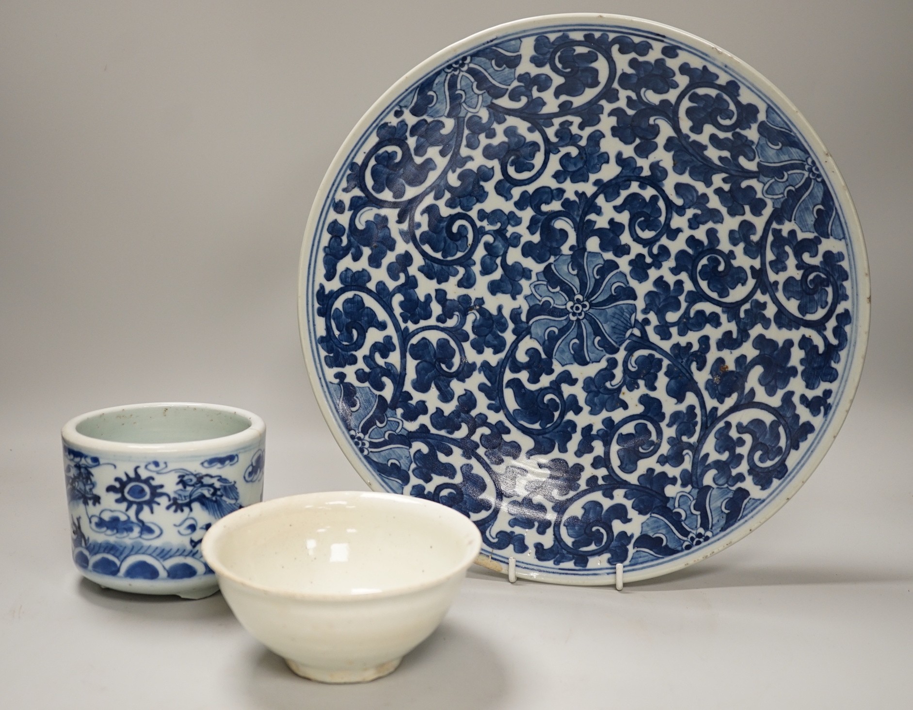 A Chinese blue and white ‘lotus’ charger, together with a bowl and dragon pot on tripod base